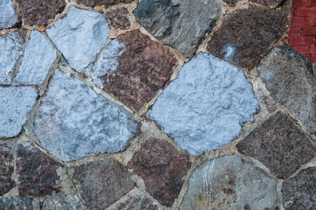 Rustic stone wall showing rough granite textures and solid construction. Natural masonry patternの写真素材