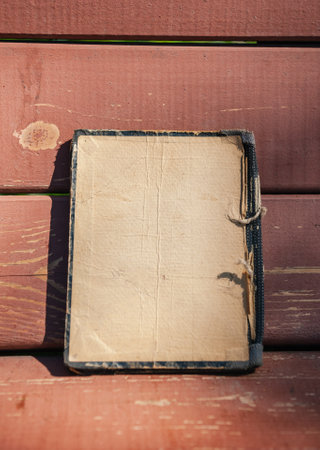 Vintage empty paper lies on the old wooden texture background of benchの写真素材