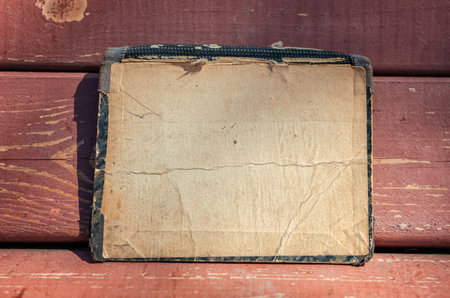 Vintage empty paper lies on the old wooden texture background of benchの写真素材