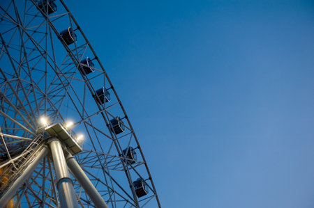 Metal structure of the ferris wheel against evening blue sky backgroundの写真素材