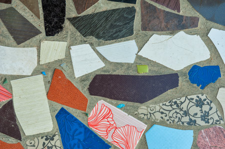 Rough concrete texture with colorful ceramic mosaic made of broken tile pieces