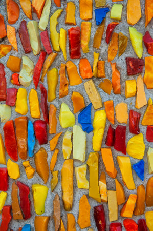 Colorful mosaic pattern with vibrant ceramic fragments on concrete surface