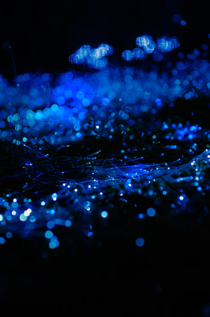 Abstract lights and bokeh form of blue fiber optics glow in a surreal night field creating a magical digital illusionの写真素材