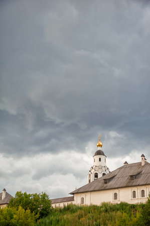 Orthodox church with golden dome rises under dramatic cloudy skyの写真素材