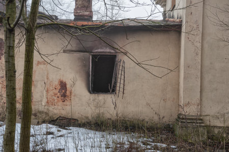 The weathered facade of the abandoned building with a broken window