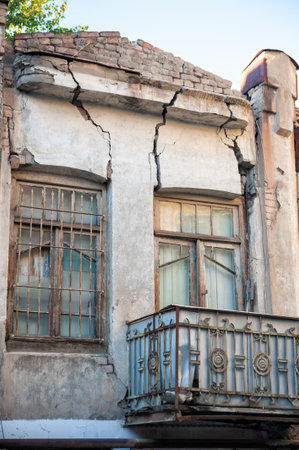 Abandoned building facade shows cracks, decay and urban deterioration
