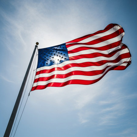 Flag of the United States of America waving in the wind against blue sky