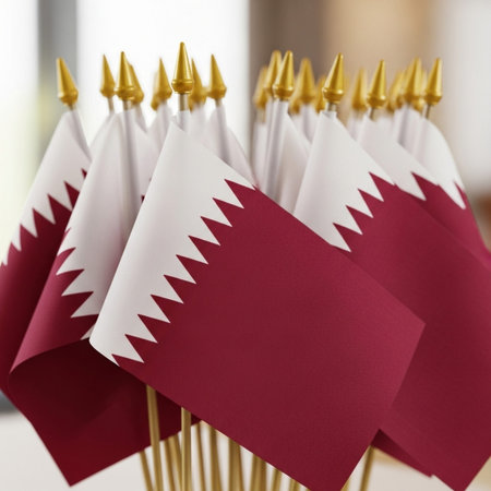 Flag of Qatar on sticks on blurred background, shallow depth of field