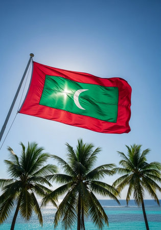 Maldives flag waving in the wind with coconut trees and blue skyの写真素材