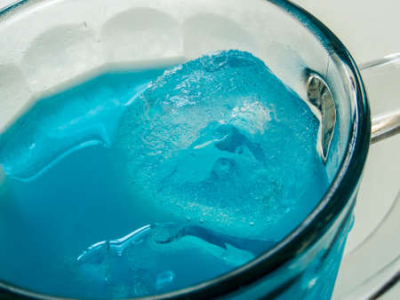 Blue water on ice in big glass of break time of officerの写真素材