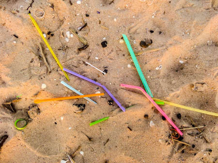 waste on beach, rainbow straws has droped on sand
