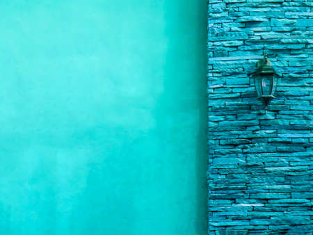 Lamp in middle blue  ancient stone pieces wall at right and smooth wall at leftの写真素材