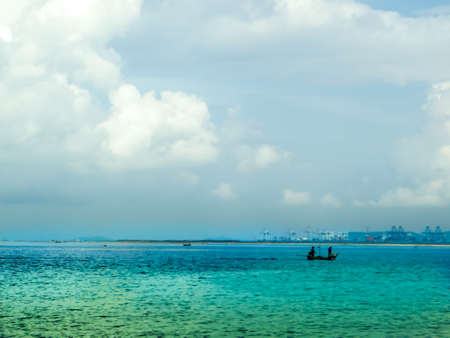 Two fisherman on fishing boat come home on horizon lineの写真素材