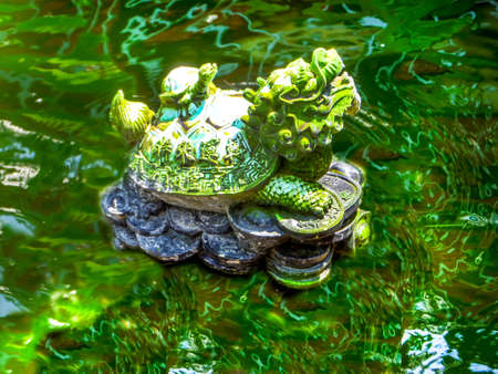 gold green dragon turtle Pixiu at pool and water mirror surface, chinese people and some asian...