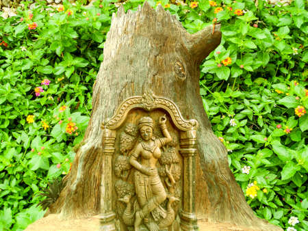 angel curving on tree and lantana flower bloom backgroundの写真素材