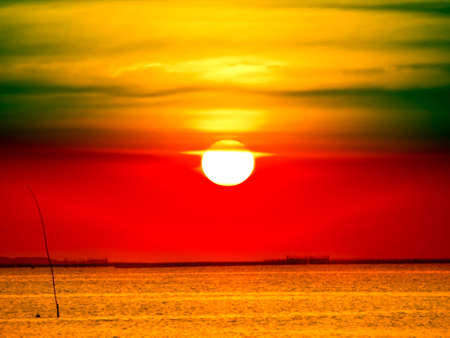 full sunset and gold color on sea surface in eveningの写真素材