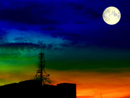 super full blood moon and blur shadow signal pillar on silhouette roofの写真素材