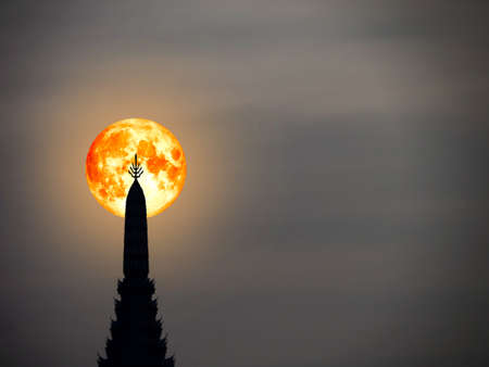 super blood moon in night sky and silhouette top of ancient pagodaの写真素材