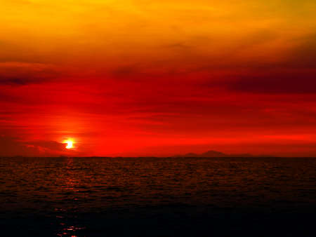 sunset last light of sun on horizontal in left frame line over night oceanの写真素材