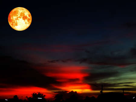 full blood moon on colorful sky in orange and dark gray cloud.の写真素材