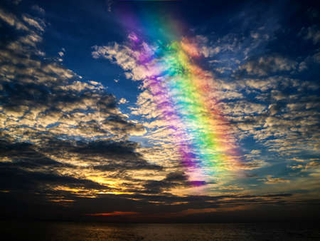sunset on the ocean and rainbow spread sunset cloudの写真素材