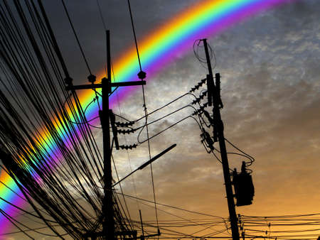 silhouette power electric line and rainbow in sunset sky