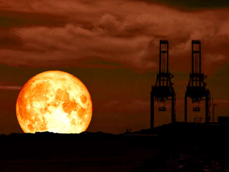 super full blood moon red sky and silhouette crane at seaport.の写真素材