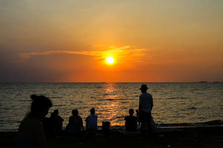 silhouette people family and pet playing at beach and sea sand sunset backgroundの写真素材