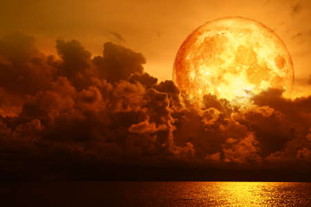 full blood moon over silhouette cloud on the sea