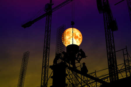 full blood moon back silhouette worker on constructionの写真素材