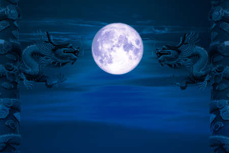 Christmas moon back between two pillars of dragon night skyの写真素材