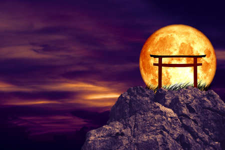 blood moon back torii over grass stone and rock of cliffの写真素材