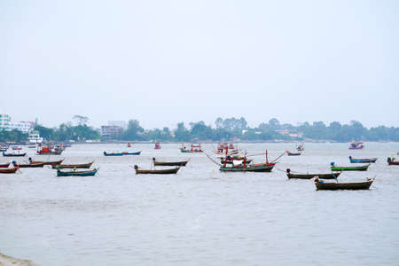Fishing boats are anchored near the shore as a storm warning and strong windsの写真素材