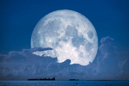 super snow moon back on night sky silhouette cloudon sea