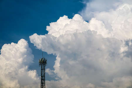white heap cloud  back on signal pole on blue sky