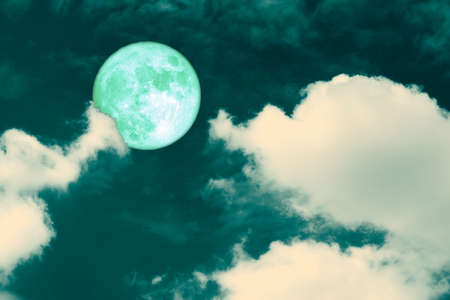 green strawberry moon back on silhouette heap cloud on night skyの写真素材
