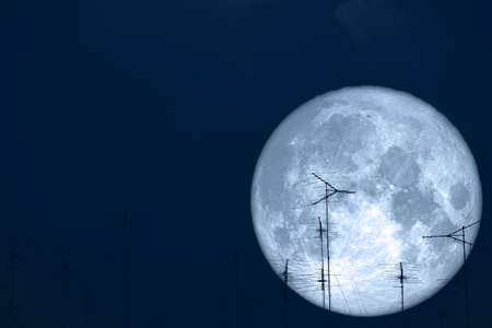 full milk moon back on silhouette antennas on night skyの写真素材