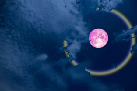 full pink halo moon and rainbow on night skyの写真素材