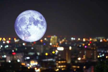 super super full harvest moon on night sky and reflection light of city on windowの写真素材