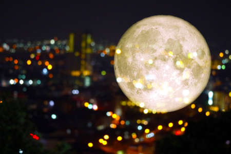 super super full harvest moon on night sky and reflection light of city on windowの写真素材