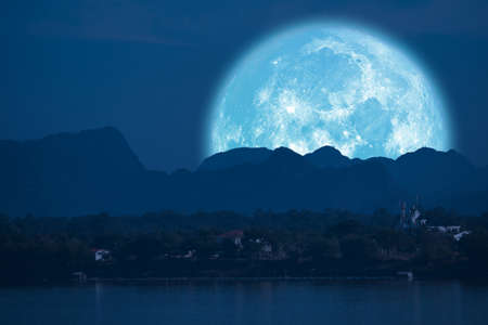 full Beaver Moon back on mountain and reflection on river in the night skyの写真素材