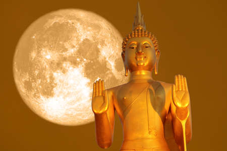 Buddha pacifying the ocean and full moon on orange sky in the Asanha bucha day.の写真素材