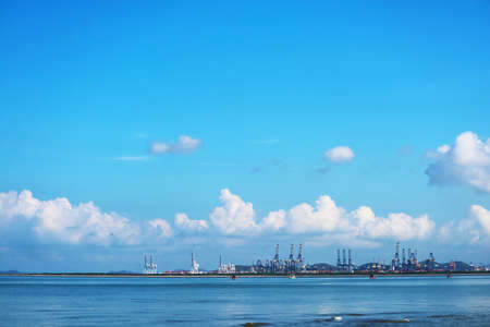cranes on seaport and blue sky white tiny cloud and fishing boats are parking on seaの写真素材