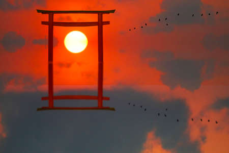 reflection torii sunset red gray cloud on the sky and silhouette birds flying on the seaの写真素材