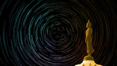 star trail on the sky back Buddha looking seven day style standing statusの写真素材