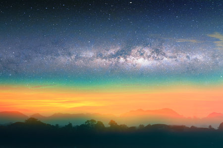 Milky way night landscape sunset rainbow light over silhouette mountain, space and stars on sky...