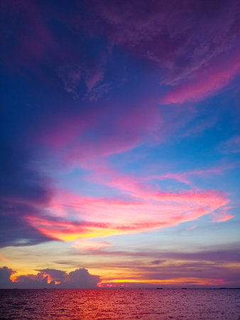 Sunset red orange purple cloud on light and dark blue sky on the seaの写真素材