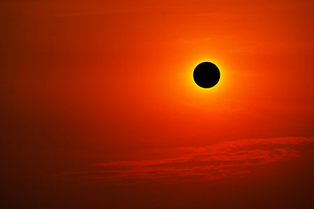 Total solar eclipse on clear red orange sky sunset in the eveningの写真素材