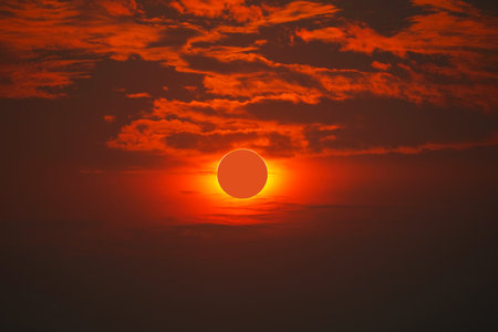 Solar eclipse on clear red orange sky sunset in the eveningの写真素材