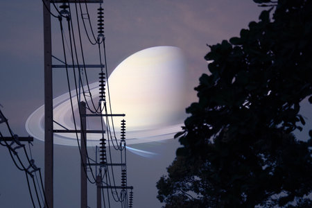 Saturn near earth over silhouette power electric poles and top tree on the night gray sky, Elements of this image furnished by NASAの写真素材